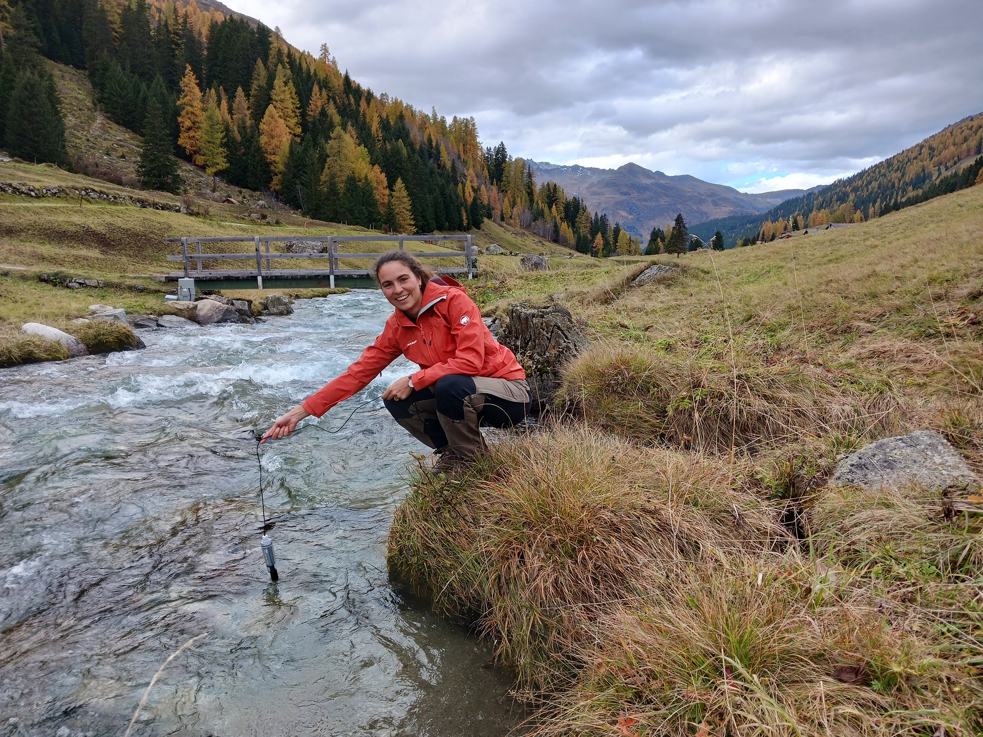 SLF-Hydrologin Amber van Hamel hält einen Sensor in den Dischmabach bei Davos.