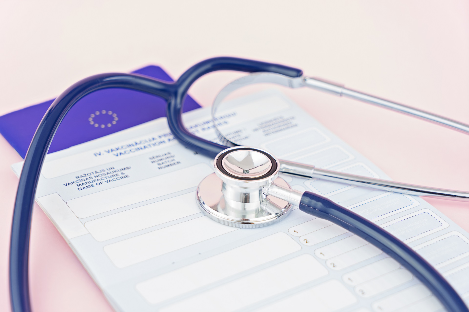 Stethoscope and pet animal vet passport. Time to do the vaccination. The concept of preparing pet for travel. First puppy vaccination and pet care, shallow depth of field Ein EU-Heimtierausweis und ein Stethoskop liegen auf einem Tisch.