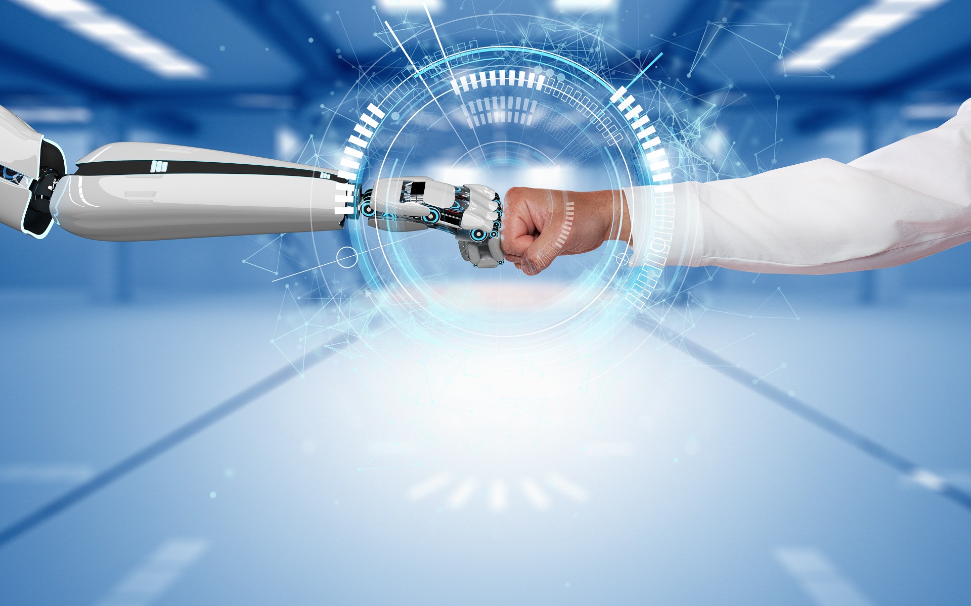 Ein Roboterhand und eine Hand von einer Person berühren sich mit geballten Händen.