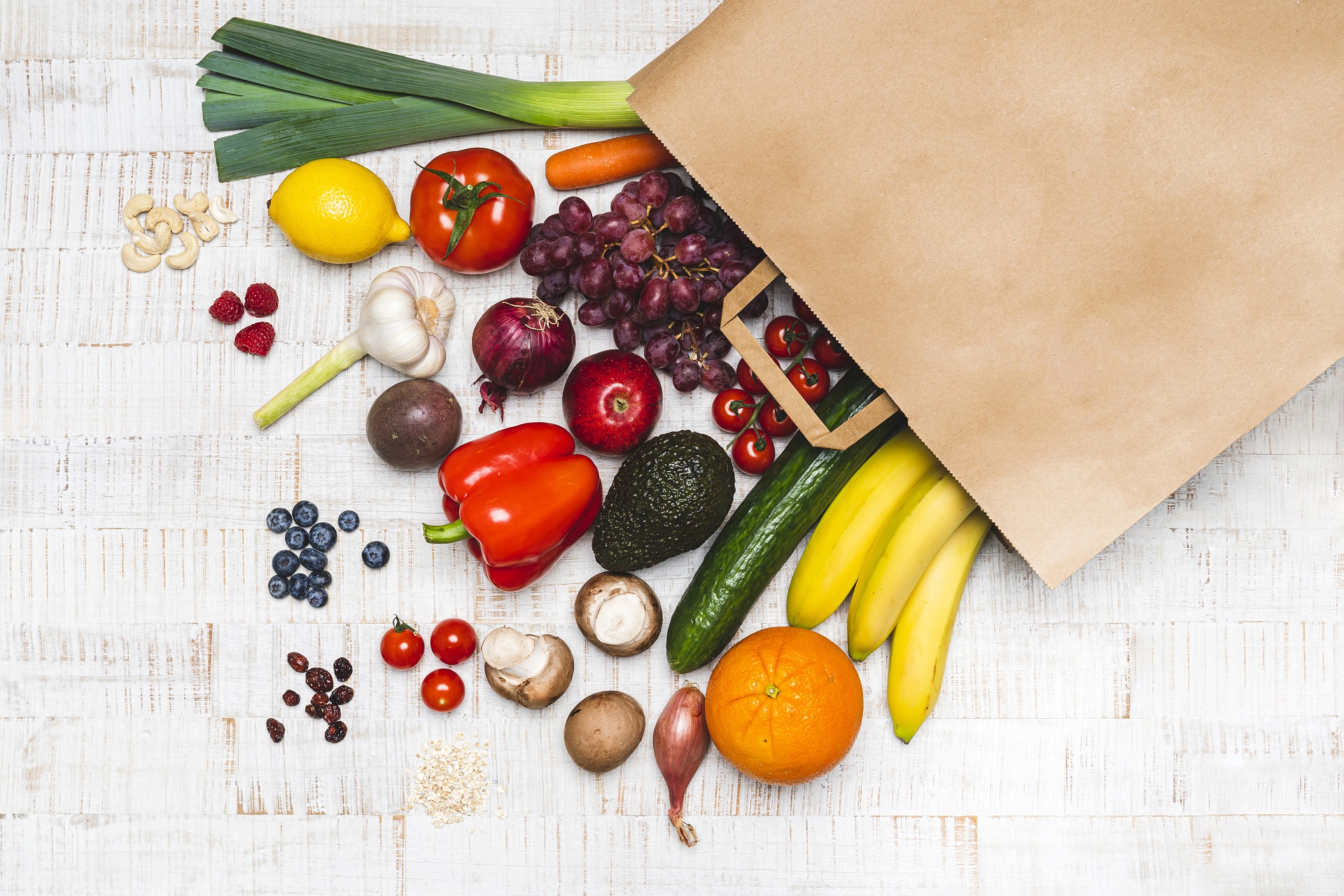 Lebensmittel liegen vor einer Papiertüte ausgebreitet.