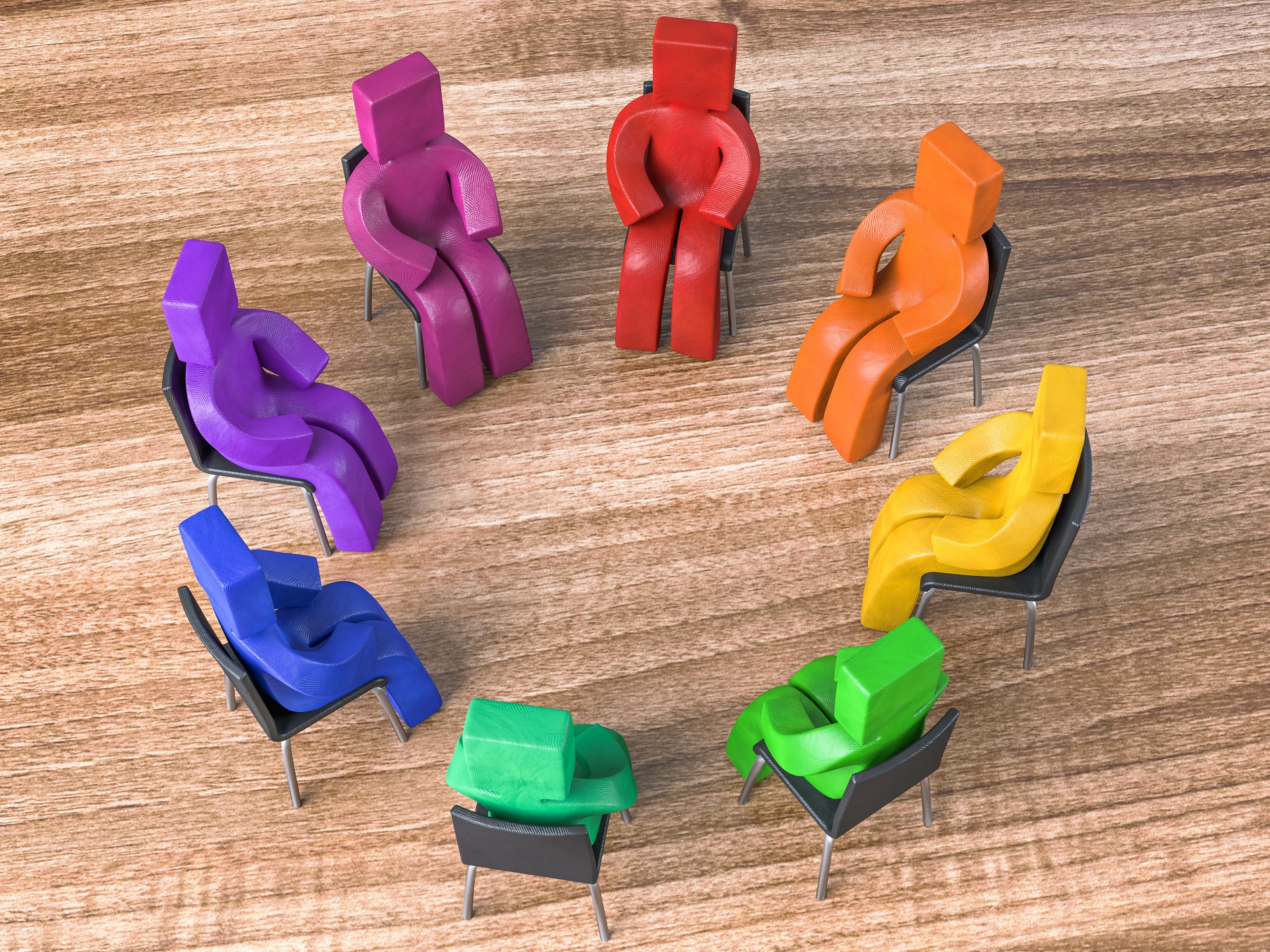 Bunte Knetfiguren in Rot-, Blau- und Grüntönen sitzen in einem Stuhlkreis auf schwarzen Stühlen.