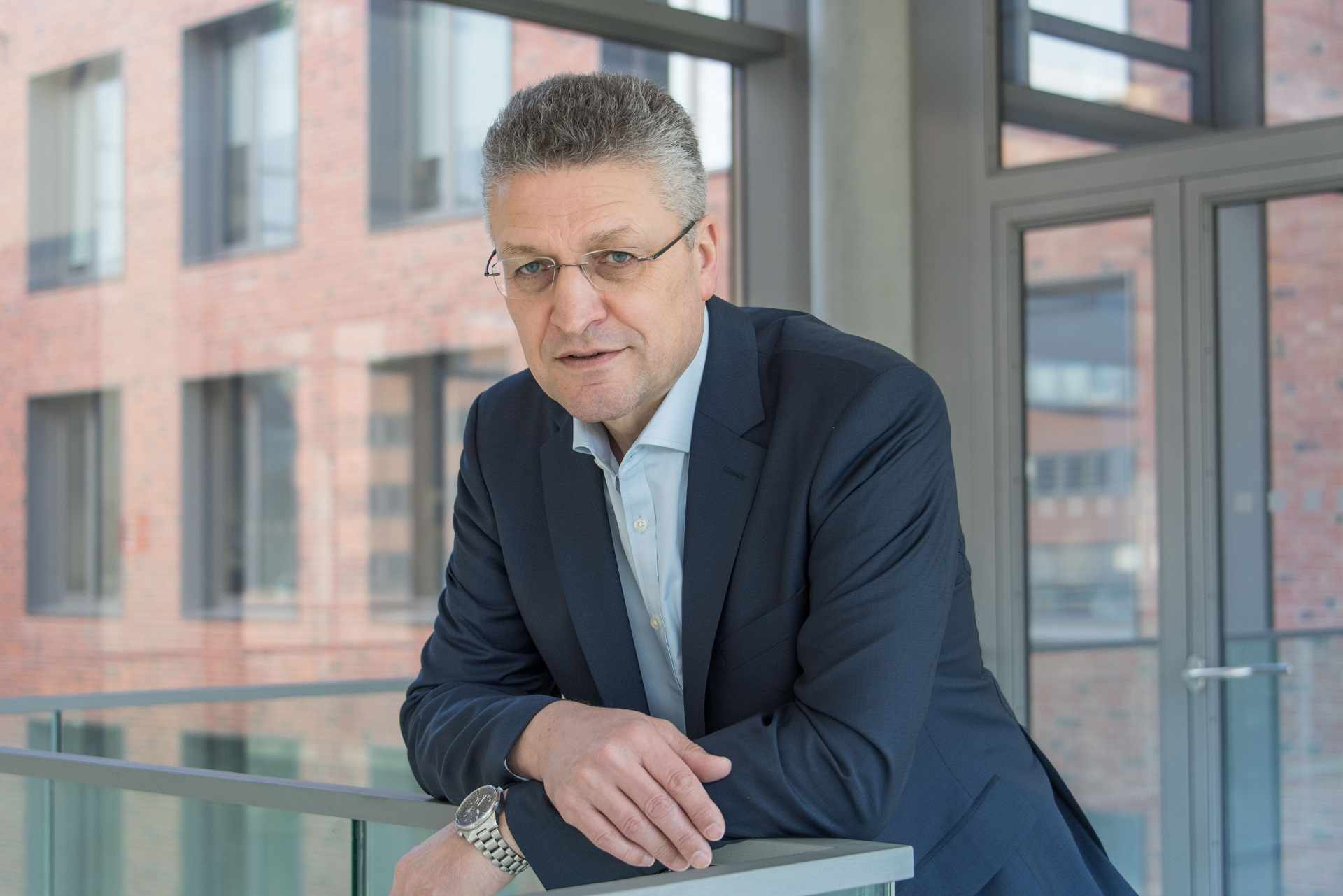 Personenbild von Lothar Wieler an einem Geländer angelehnt.